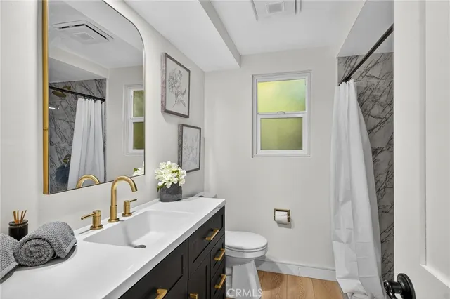 a bathroom with a sink a toilet and a mirror