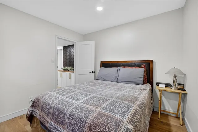 a bedroom with a bed and a lamp on the dresser