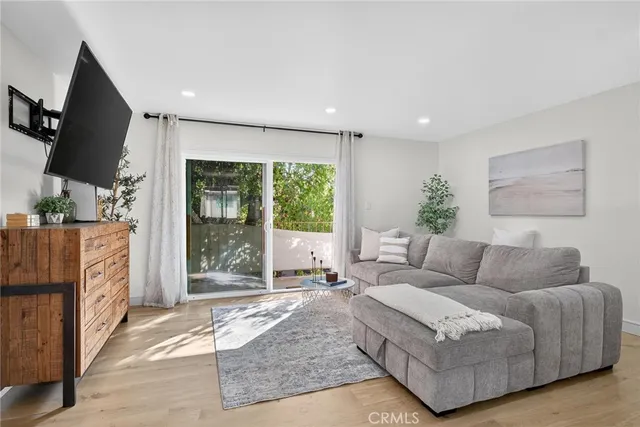 a living room with furniture large window and flat screen tv
