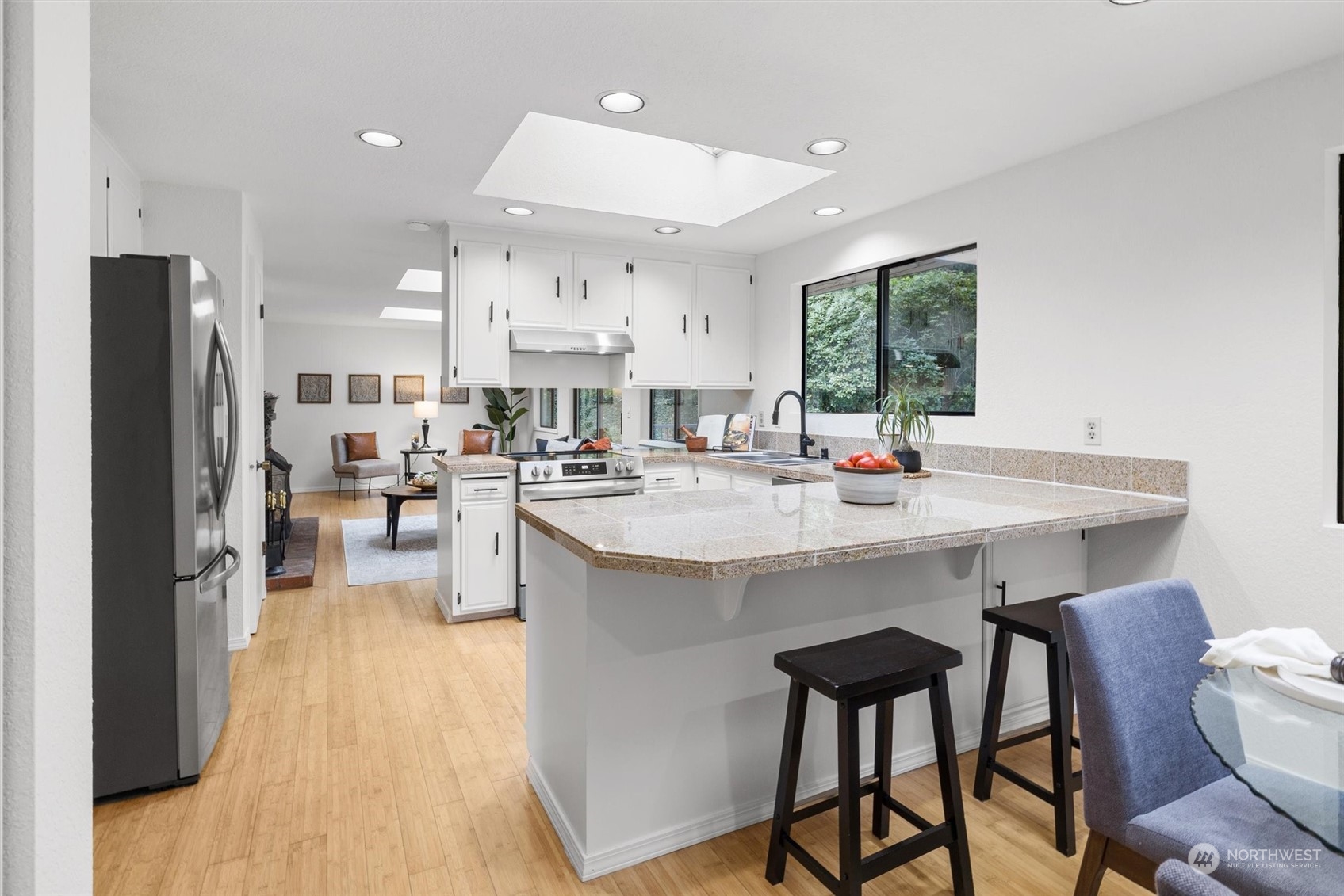 17631 7th Avenue West Bothell, WA 98012 - Photo 16 of 38 a kitchen with stainless steel appliances kitchen island granite countertop a table chairs and a refrigerator