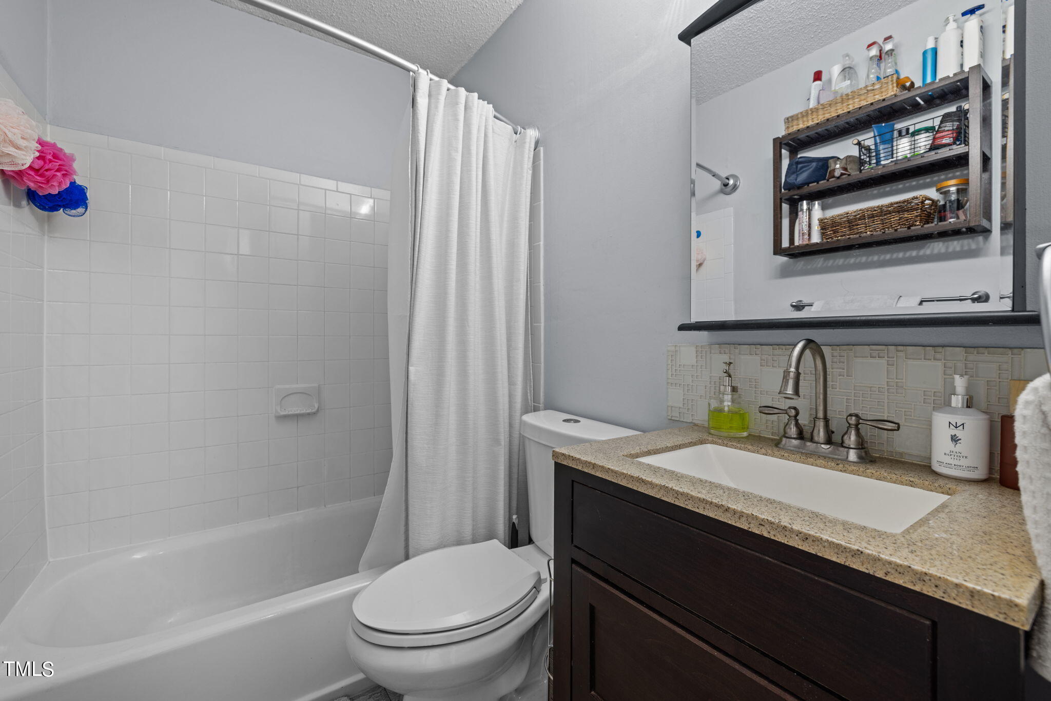 709 Godwin Court Raleigh, NC 27606 - Photo 19 of 31 a bathroom with a granite countertop sink a toilet and shower