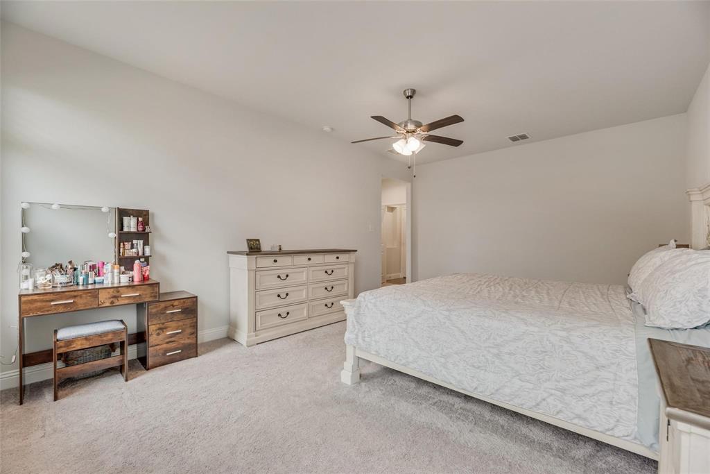 1271 Altuda Drive Forney, TX 75126 - Photo 19 of 35 a bedroom with a bed and a chandelier