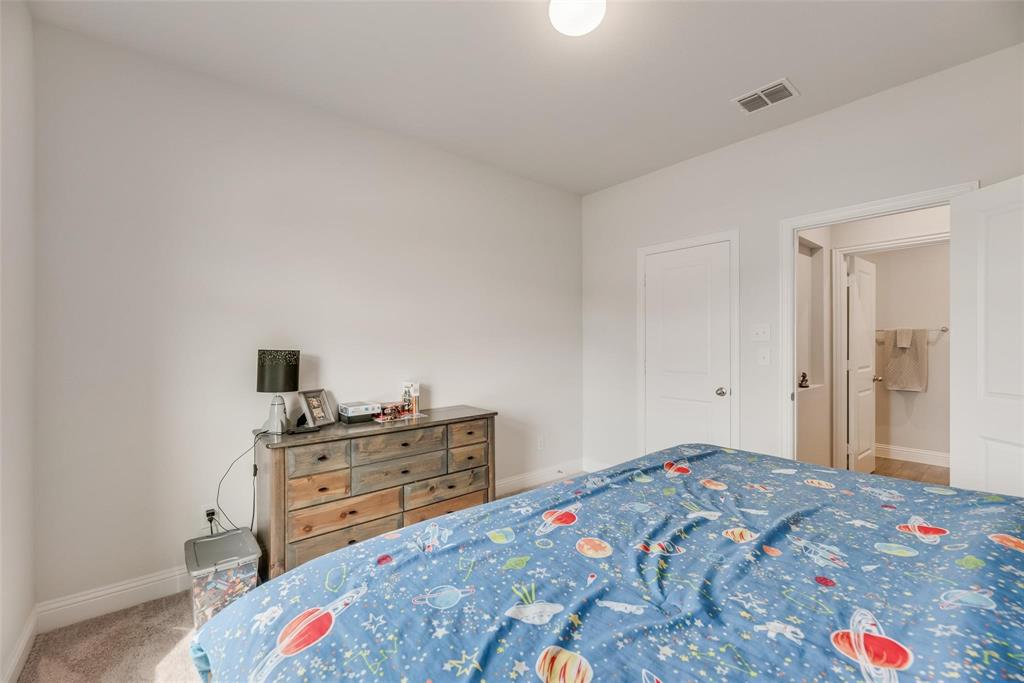 1271 Altuda Drive Forney, TX 75126 - Photo 26 of 35 a bedroom with a bed and a lamp on dresser