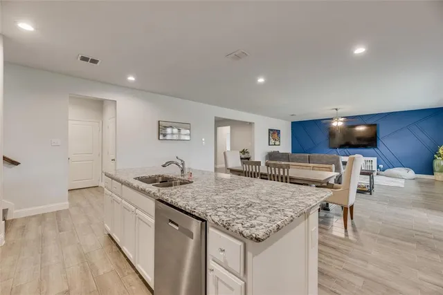 a kitchen with a counter space appliances and wooden floor