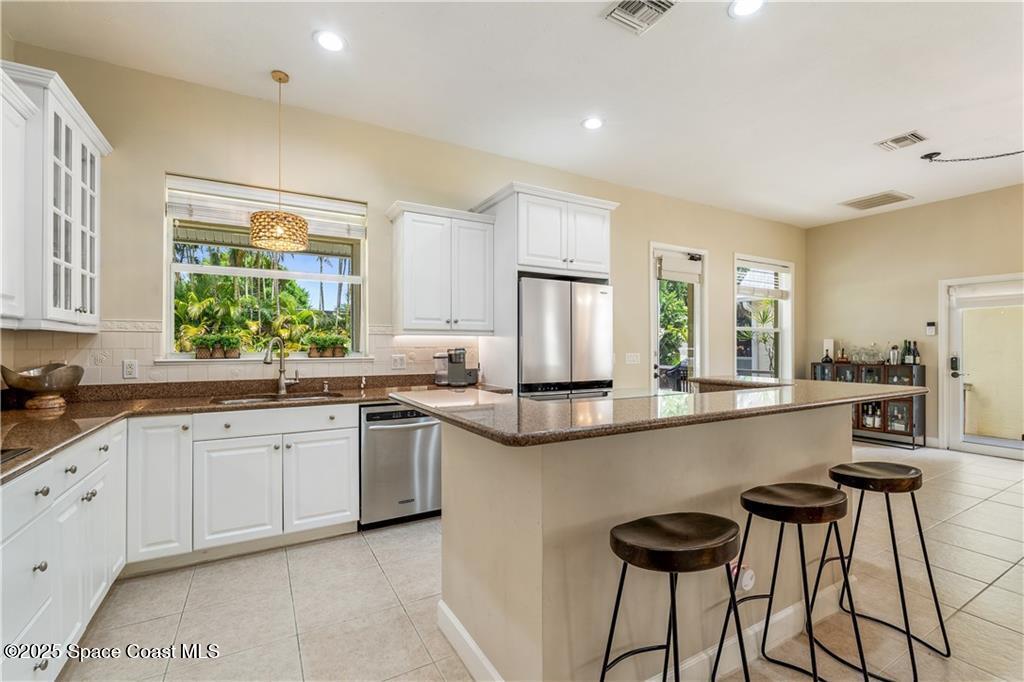 Undisclosed Address Vero Beach, FL 32966 - Photo 13 of 36 a large kitchen with kitchen island white cabinets and stainless steel appliances