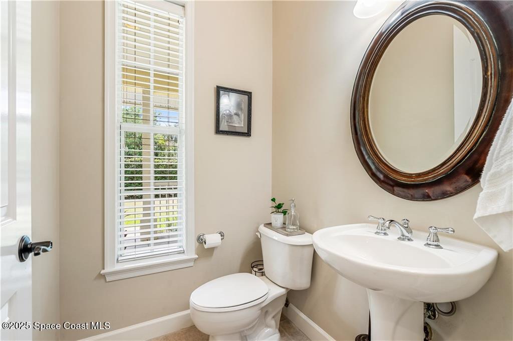 Undisclosed Address Vero Beach, FL 32966 - Photo 24 of 36 a bathroom with a sink a toilet and a mirror