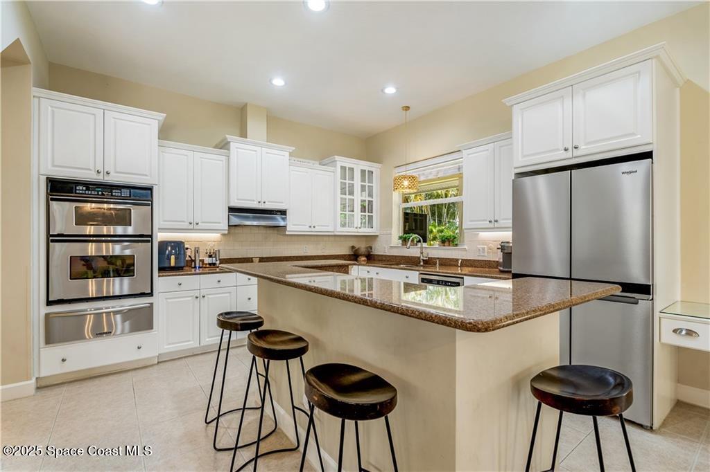 Undisclosed Address Vero Beach, FL 32966 - Photo 5 of 36 a kitchen with stainless steel appliances granite countertop a stove a sink and a refrigerator