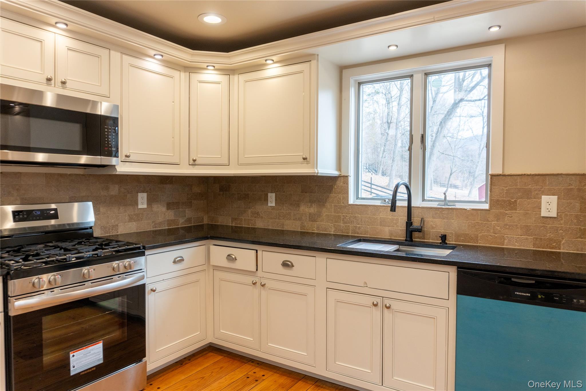 523 Shenandoah Road Hopewell Junction, NY 12533 - Photo 2 of 27 a kitchen with granite countertop a sink a stove and cabinets