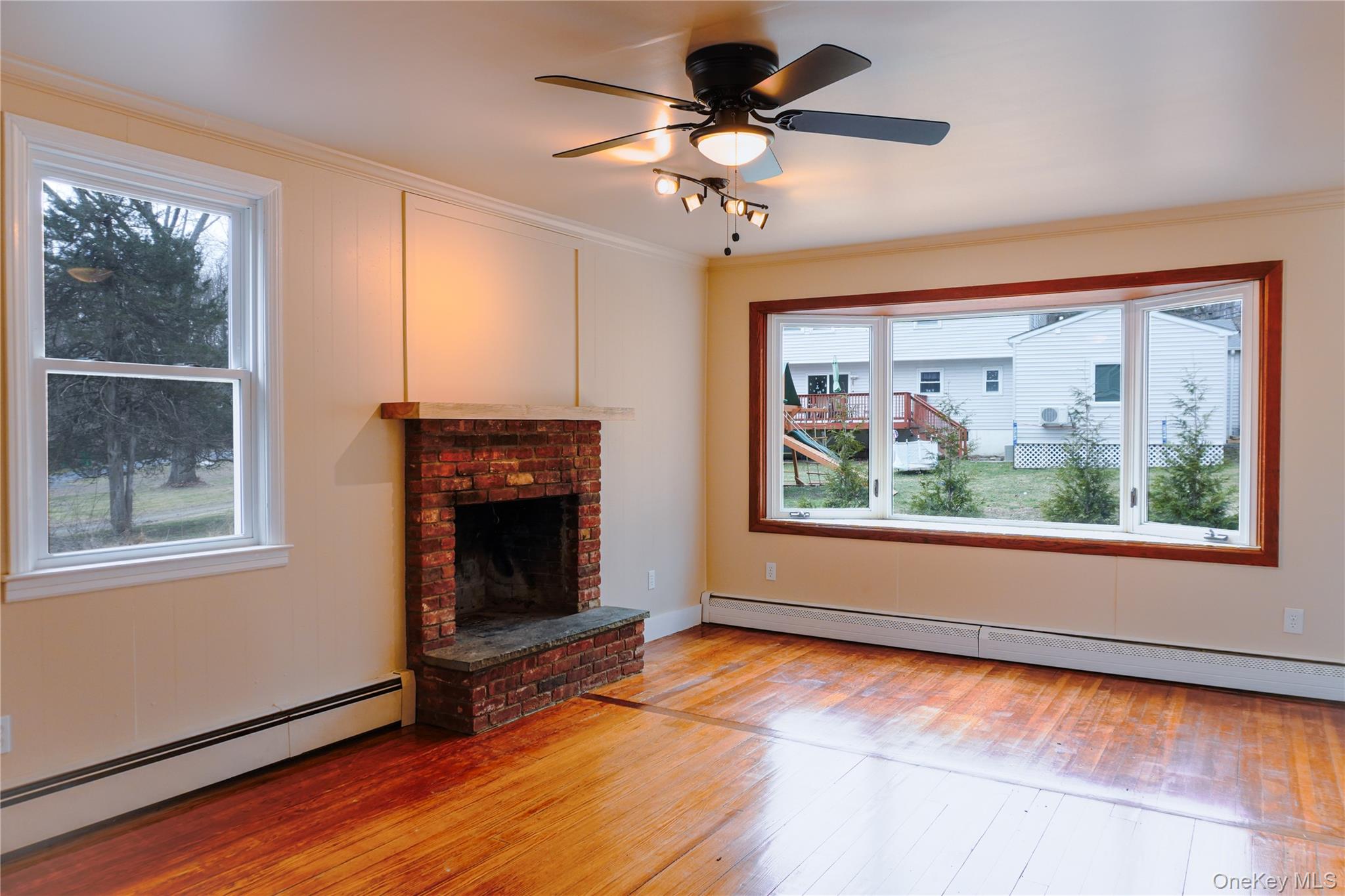 523 Shenandoah Road Hopewell Junction, NY 12533 - Photo 9 of 27 an empty room with windows fireplace and fan