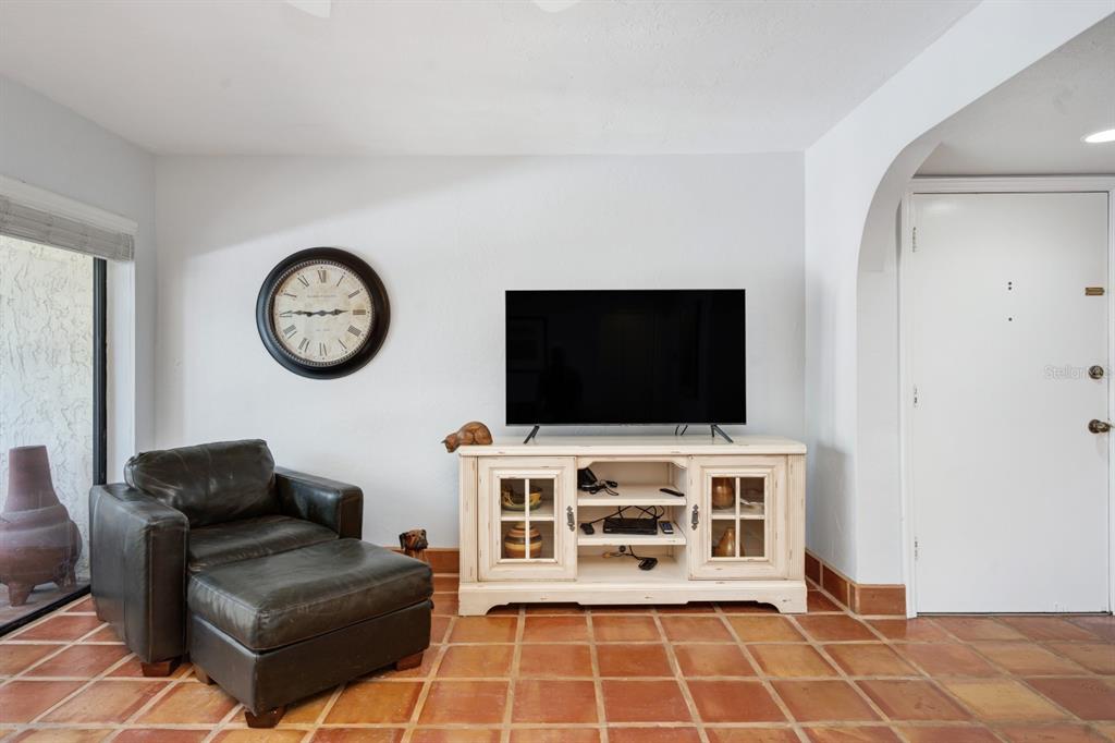 6157 Midnight Pass Road, Unit E22 Sarasota, FL 34242 - Photo 11 of 48 a living room with furniture and a flat screen tv