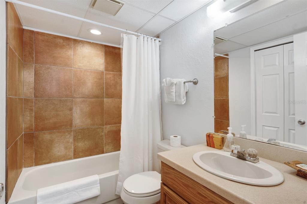 6157 Midnight Pass Road, Unit E22 Sarasota, FL 34242 - Photo 15 of 48 a bathroom with a sink a toilet and shower