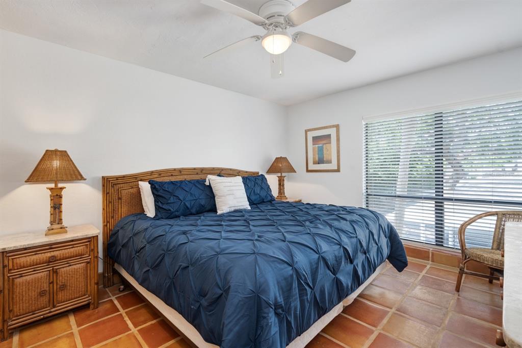 6157 Midnight Pass Road, Unit E22 Sarasota, FL 34242 - Photo 16 of 48 a bedroom with a bed and wooden floor