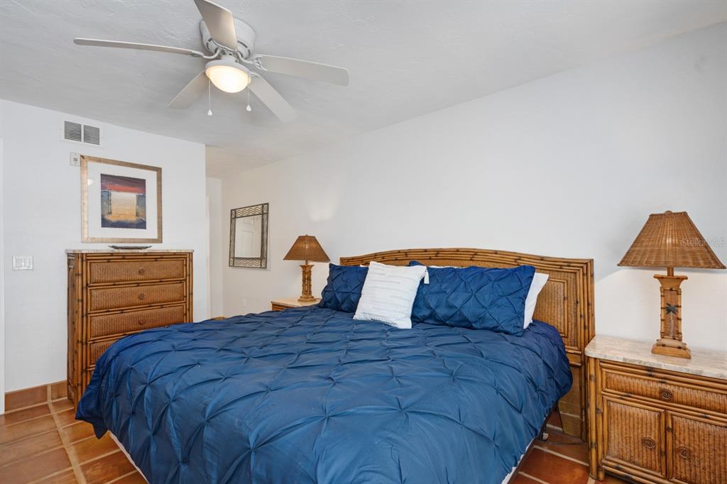 6157 Midnight Pass Road, Unit E22 Sarasota, FL 34242 - Photo 17 of 48 a bedroom with a bed and a chandelier