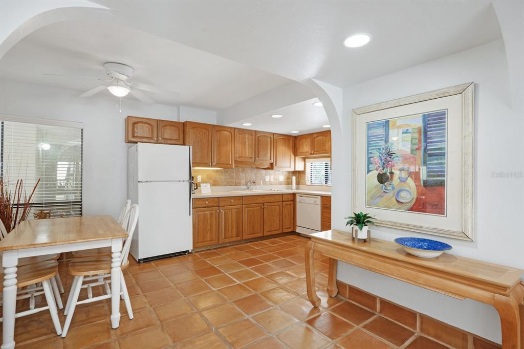 6157 Midnight Pass Road, Unit E22 Sarasota, FL 34242 - Photo 2 of 48 a kitchen with stainless steel appliances kitchen island granite countertop a refrigerator and a stove top oven