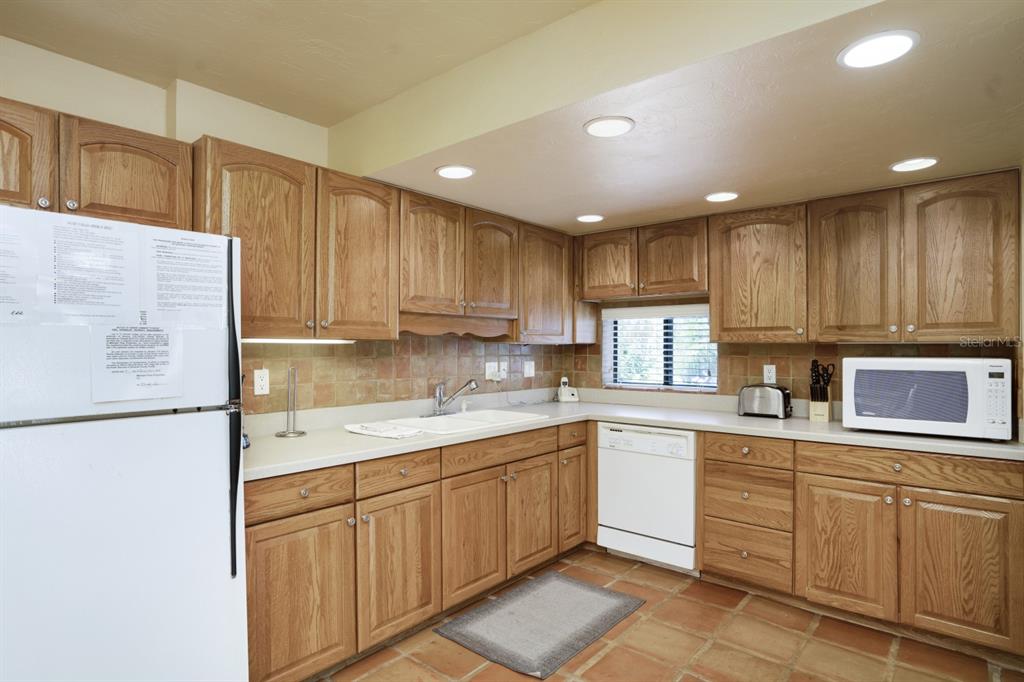 6157 Midnight Pass Road, Unit E22 Sarasota, FL 34242 - Photo 22 of 48 a kitchen with kitchen island sink refrigerator and cabinets