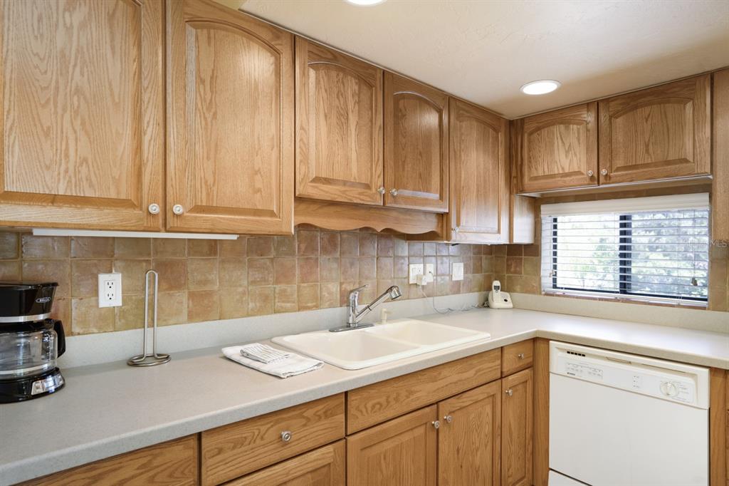 6157 Midnight Pass Road, Unit E22 Sarasota, FL 34242 - Photo 23 of 48 a kitchen with a sink cabinets and window