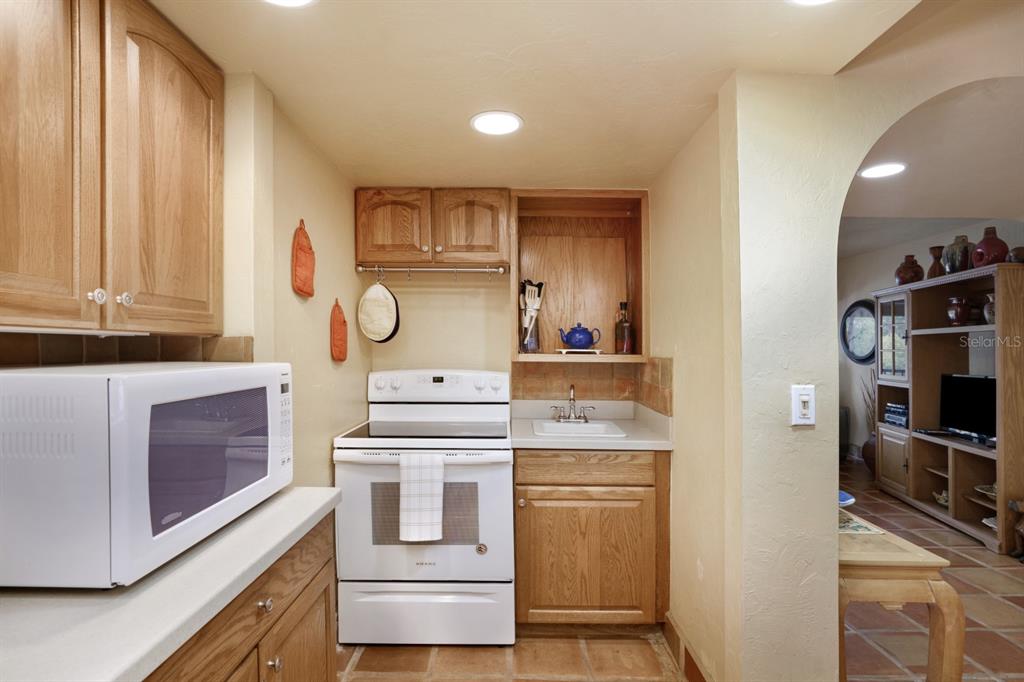 6157 Midnight Pass Road, Unit E22 Sarasota, FL 34242 - Photo 24 of 48 a kitchen with stainless steel appliances granite countertop a stove and a refrigerator