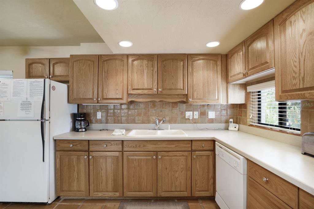 6157 Midnight Pass Road, Unit E22 Sarasota, FL 34242 - Photo 25 of 48 a kitchen with stainless steel appliances granite countertop a sink stove and refrigerator