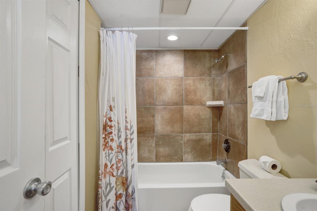 6157 Midnight Pass Road, Unit E22 Sarasota, FL 34242 - Photo 37 of 48 a bathroom with a bathtub and a shower
