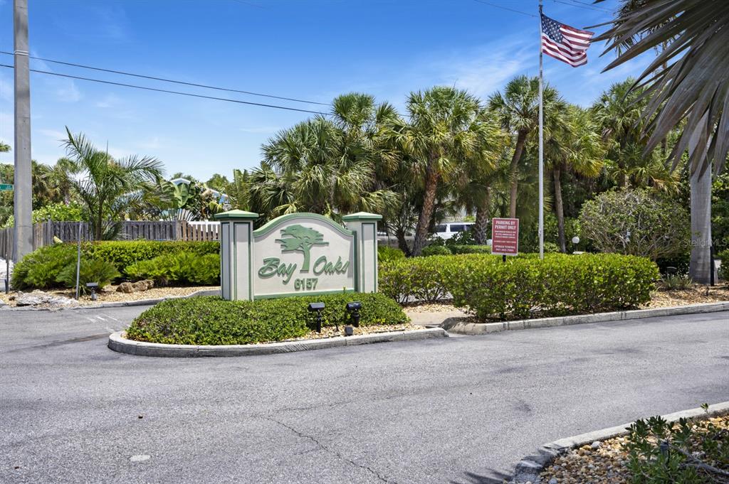 6157 Midnight Pass Road, Unit E22 Sarasota, FL 34242 - Photo 41 of 48 a front view of a house with a yard and outdoor seating