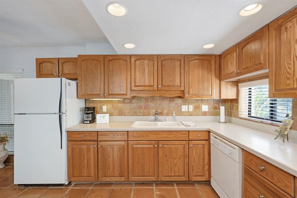 6157 Midnight Pass Road, Unit E22 Sarasota, FL 34242 - Photo 7 of 48 a kitchen with stainless steel appliances granite countertop a refrigerator sink and cabinets