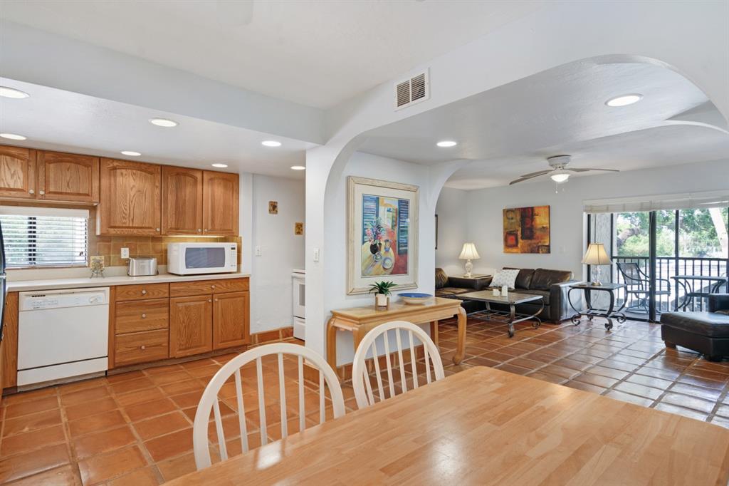 6157 Midnight Pass Road, Unit E22 Sarasota, FL 34242 - Photo 8 of 48 a kitchen with lots of counter top space dining table and stainless steel appliances