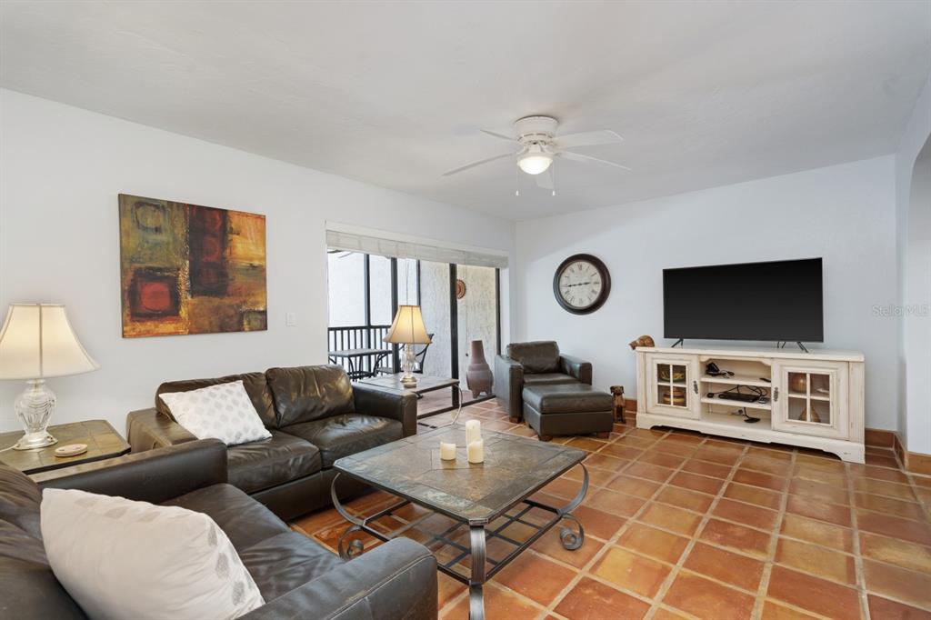 6157 Midnight Pass Road, Unit E22 Sarasota, FL 34242 - Photo 10 of 48 a living room with furniture a flat screen tv and a window
