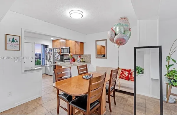 a dining room with furniture a kitchen view and chandelier
