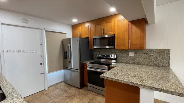 a kitchen with stainless steel appliances granite countertop a refrigerator stove and microwave