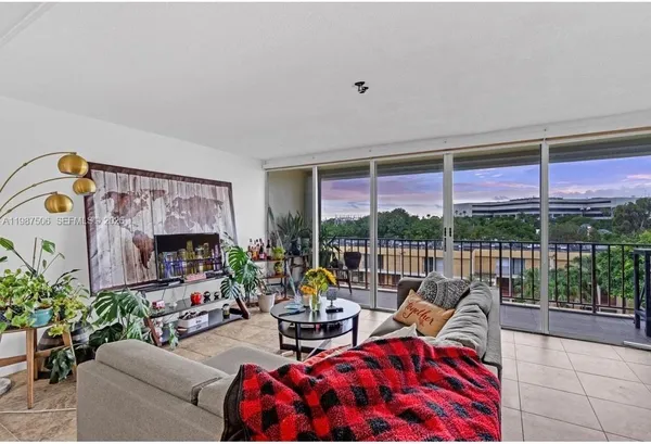 a living room with patio furniture and a large window