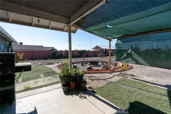a view of a dry yard with wooden fence