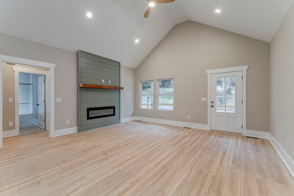 79 Logan Lane Ellijay, GA 30540 - Photo 22 of 56 an empty room with wooden floor fireplace and windows