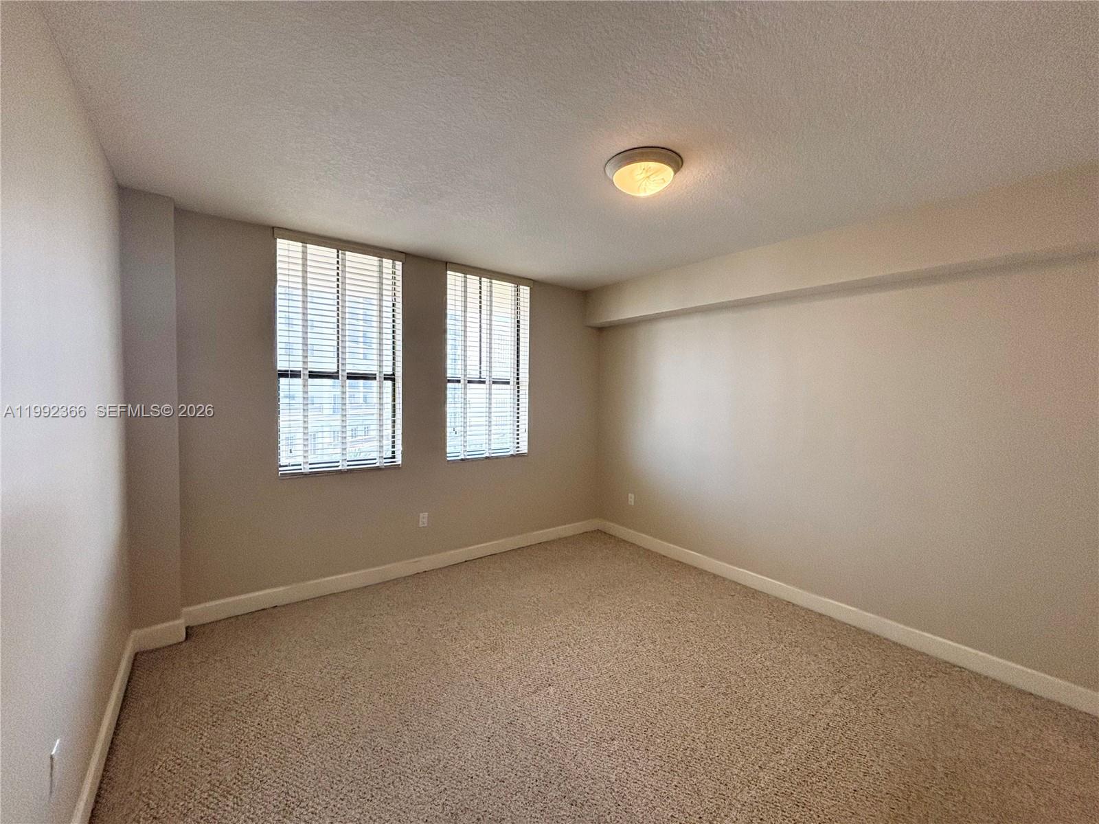 55 Merrick Way, Unit 702 Coral Gables, FL 33134 - Photo 11 of 17 an empty room with windows