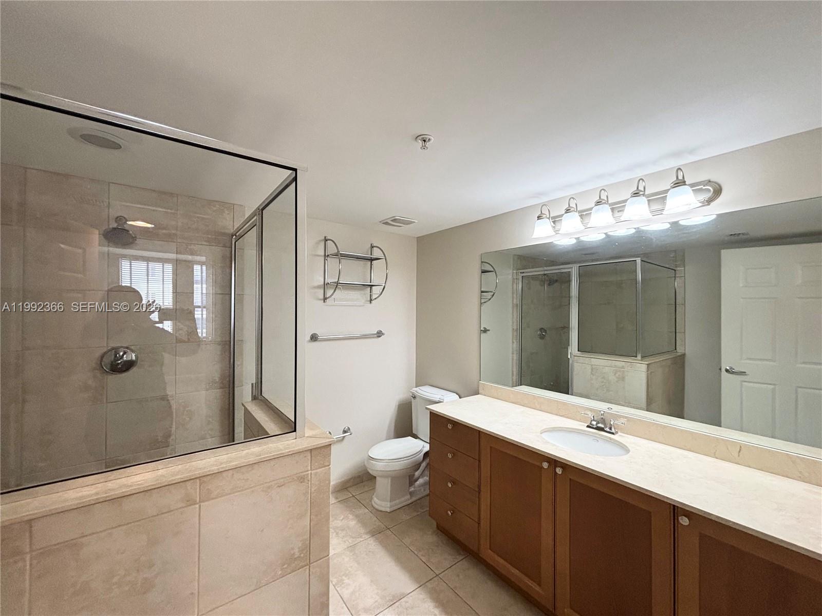 55 Merrick Way, Unit 702 Coral Gables, FL 33134 - Photo 12 of 17 a bathroom with a double vanity sink mirror and toilet