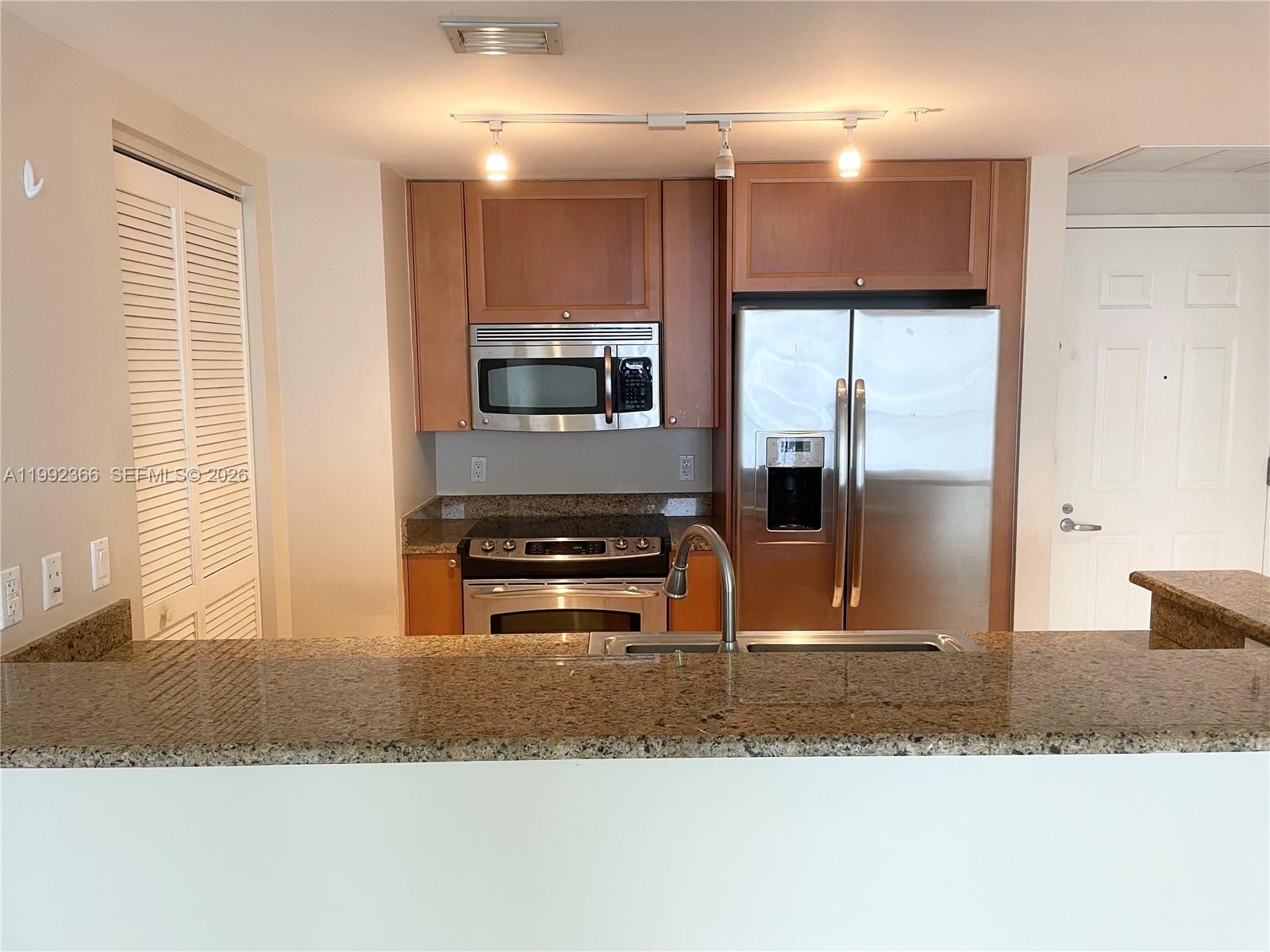 55 Merrick Way, Unit 702 Coral Gables, FL 33134 - Photo 5 of 17 a kitchen with a refrigerator and a sink