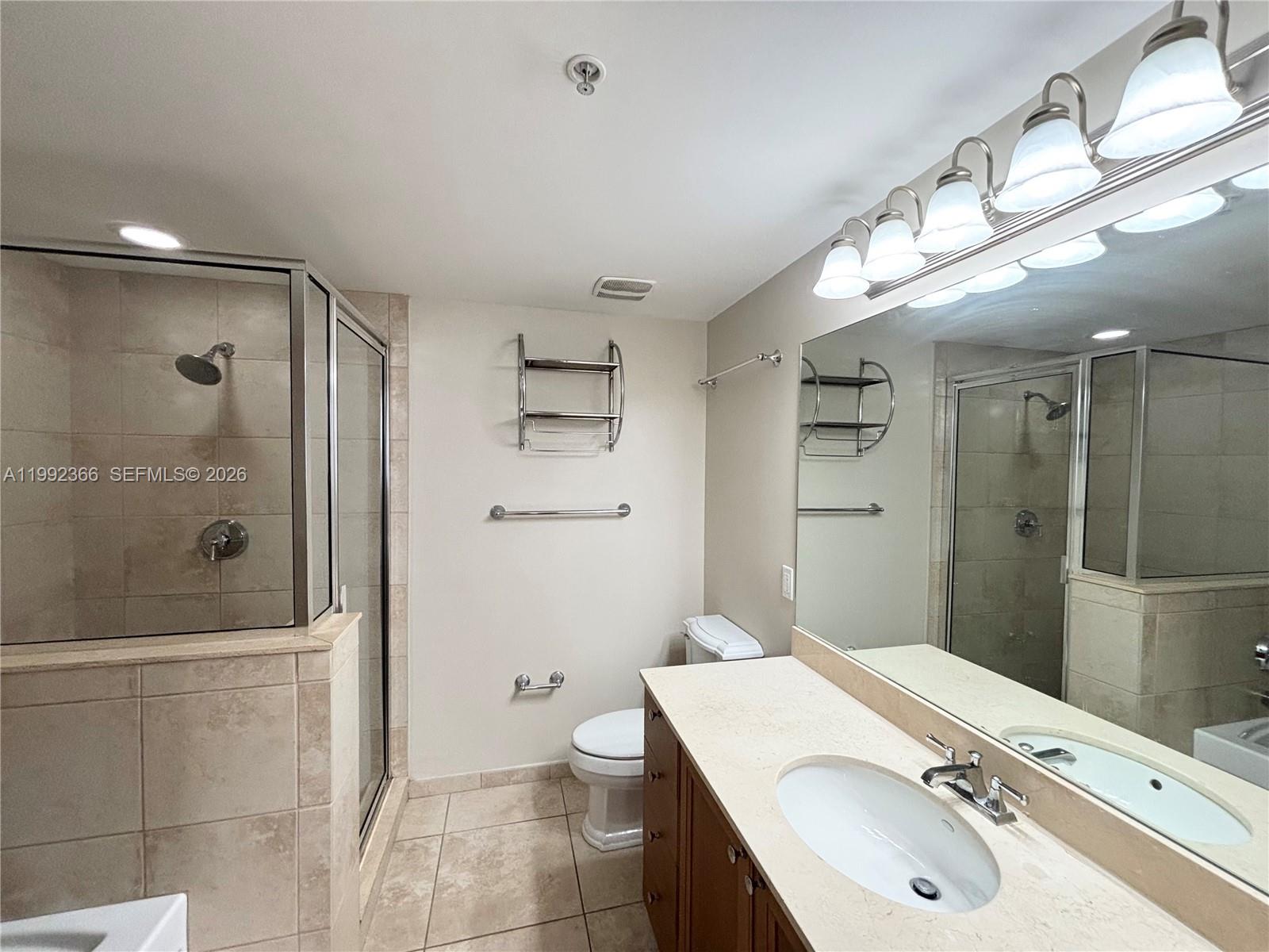 55 Merrick Way, Unit 702 Coral Gables, FL 33134 - Photo 9 of 17 a bathroom with a sink a toilet and shower