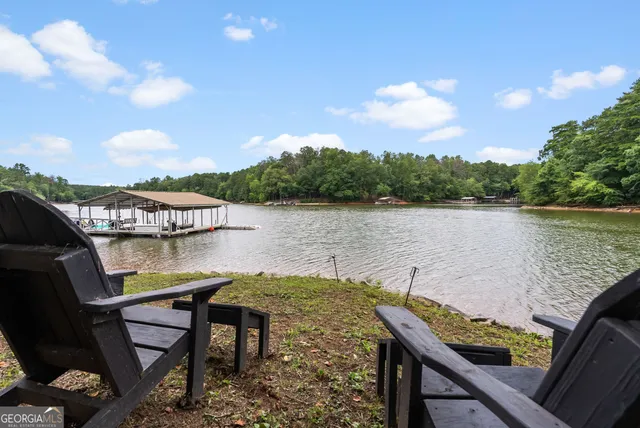 a backyard of a house with table and chairs and a large tree
