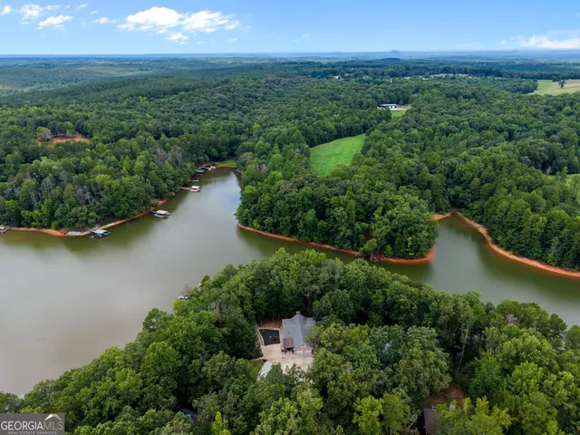 an aerial view of a house with a yard and lake view