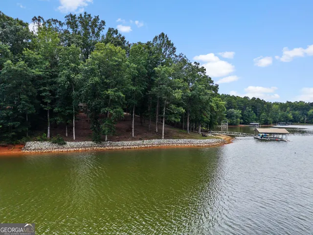a view of swimming pool with seating area and trees in the background