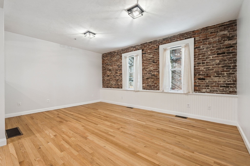 172 Cottage Street, Unit 2 Boston, MA 02128 - Photo 13 of 33 a view of an empty room with wooden floor and a window