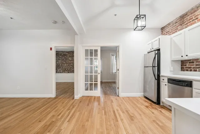 a view of empty room with wooden floor and stove
