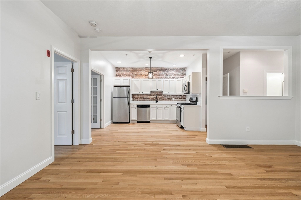 172 Cottage Street, Unit 2 Boston, MA 02128 - Photo 2 of 33 a view of a kitchen with stainless steel appliances wooden floor and large window