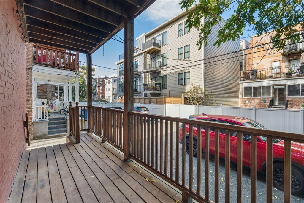 172 Cottage Street, Unit 2 Boston, MA 02128 - Photo 30 of 33 a view of a balcony with wooden floor and fence and a floor to ceiling window