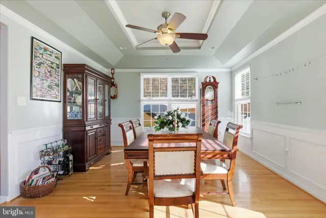 a dining room with furniture a chandelier and wooden floor