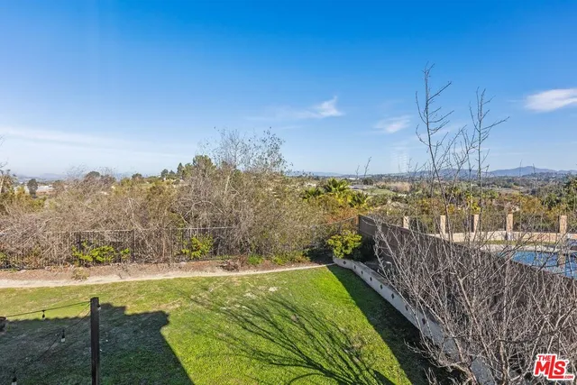 a view of a pathway both side of building with yard