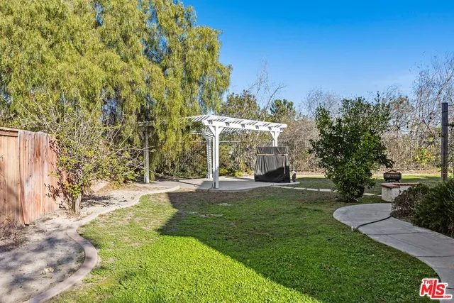 a view of a white house with a big yard and large trees