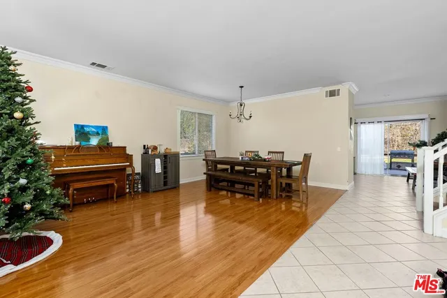 a living room with furniture and a dining table with wooden floor