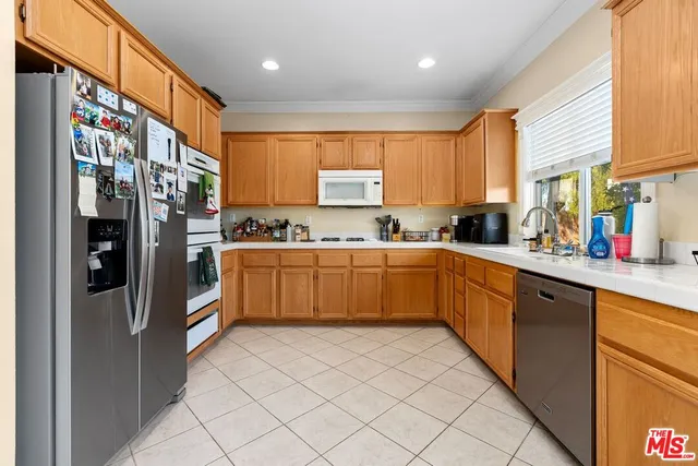 a kitchen with stainless steel appliances a refrigerator sink and cabinets