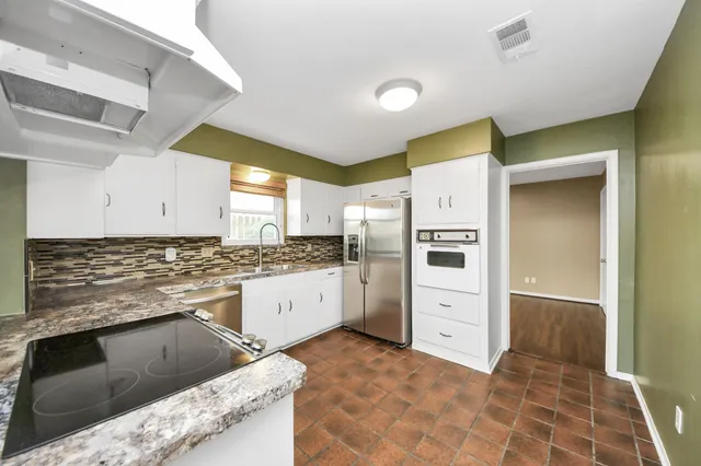 a kitchen with a refrigerator sink and cabinets