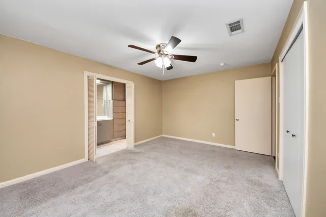 a view of an empty room and a ceiling fan